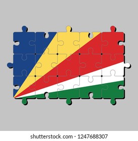 Jigsaw puzzle of seychelles flag in five oblique bands of blue yellow red white and green. Concept of Fulfillment or perfection.