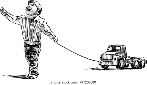 A joy little boy walks with his toy car
