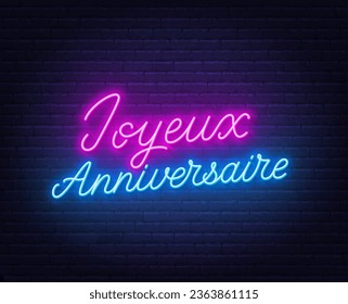 Joyeux Anniversaire neon lettering on brick wall background.