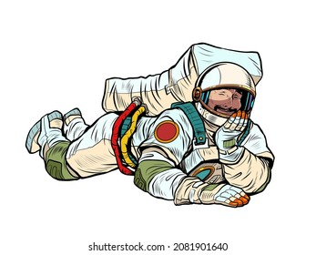 The joyful astronaut is lying down. Relaxed funny pose. Peace and relaxation