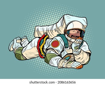 The joyful astronaut is lying down. Relaxed funny pose. Peace and relaxation