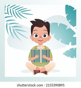 A joyful child boy sits in a lotus position and holds a gift box with a bow in his hands. Birthday, new year or holidays theme. Vector illustration in cartoon style.