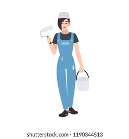 Joyful house painter or decorator wearing dungarees and holding paint roll and bucket. Funny female cartoon character isolated on white background. Colorful vector illustration in flat style.