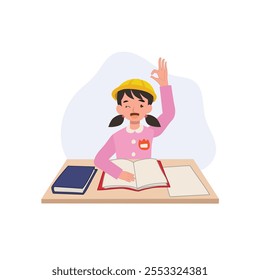 A joyful Japanese preschool girl in a kindergarten uniform sits at her desk with a raised hand, showing an OK gesture, enjoying her learning moment in class.