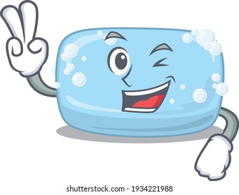 A joyful soap cartoon mascot shows two fingers gesture. Vector illustration