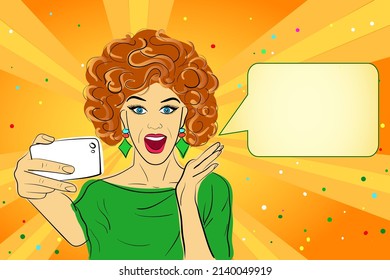 Joyful surprised woman with red hair, open mouth, with a mobile phone in her hand, green shirt, orange background