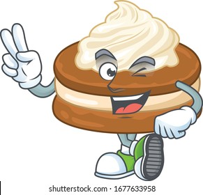 A joyful white cream alfajor mascot design showing his two fingers