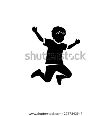 A joyful young boy is captured mid jump arms raised in playful exuberance silhouette