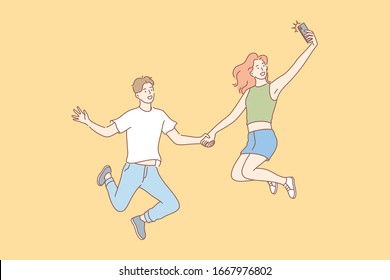 Jumping people, selfie, couple, leisure concept. Jumping people, man and woman, boyfriend girlfriend or teenagers, couple in love, taking selfie on smartphone for social media. Modern lifestyle.