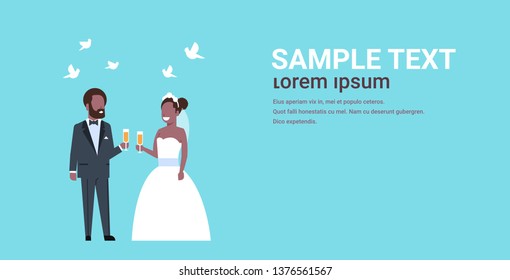 just married african american couple standing together bride and groom holding champagne glasses wedding day concept copy space full length horizontal flat