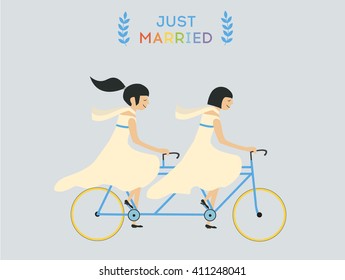Just married lesbian wedding couple riding bicycle
