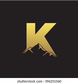 K alphabet mountain negative space letter logo gold black background