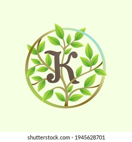 K letter logo made of twisted tree branches and green leaves in circle. Ecology vector font for vegan emblem, botanical identity, creative spring t-shirts, organic merchandise.