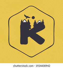 K letter logo with mountains peaks and trees on a landscape line pattern. Adventure and outdoor vintage emblem perfect for t-shirts, apparel and other merchandise.