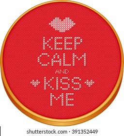 Keep Calm and Kiss Me cross stitch embroidery on wood embroidery hoop with love, a big kiss and hearts, red Aida even-weave cloth texture background needlework sampler, Valentines Day card.