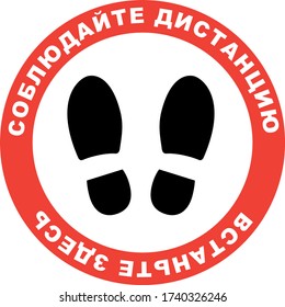 Keep Distance Stay Here in Russian. Floor sign social distance print sticker with footprint in red circle and white text. Shop que line mark. Social distancing in coronavirus era. Covid-19 protection.