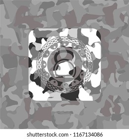 kettlebell icon inside grey camouflage emblem