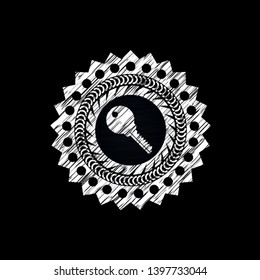 key icon inside chalk emblem written on a blackboard