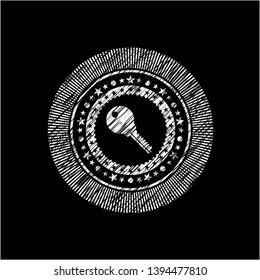 key icon inside chalkboard emblem on black board