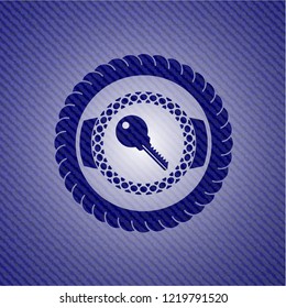 key icon inside emblem with denim texture