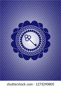 key icon inside emblem with denim texture