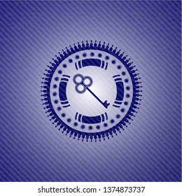 key icon inside emblem with denim texture