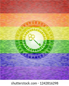 key icon inside emblem on mosaic background with the colors of the LGBT flag
