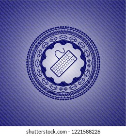 keyboard icon inside emblem with jean background