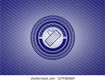 keyboard icon inside emblem with jean background