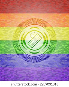 keyboard icon inside emblem on mosaic background with the colors of the LGBT flag. 