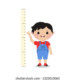 Kid measures the growth. Boy is measuring his height.