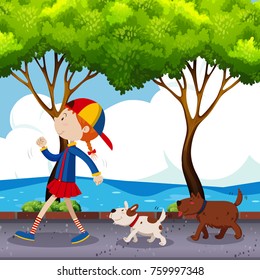 Kid walking his two dogs in a park