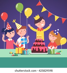 Niños con sombreros graciosos celebrando a un niño con un cumpleaños de corona con regalos, torta grande y globos de aire.  Dibujo gráfico gráfico moderno de estilo plano.