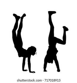 Kids silhouettes standing upside down on their hands