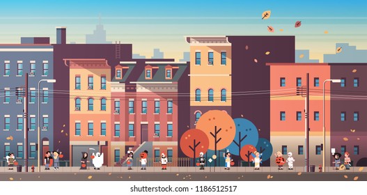 kids wearing monsters costumes walking town holiday concept cityscape background tricks or treat happy halloween cartoon character full length horizontal banner flat vector illustration