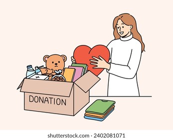 Kind woman stands near donation box with big heart in hands, wanting to help people in need. Collecting donation box of toys and books for children who find themselves in difficult financial situation