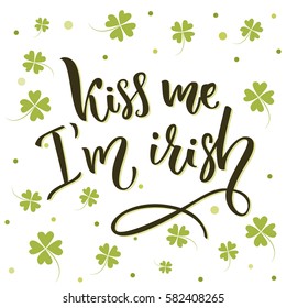 Kiss me, I'm irish. Funny St. Patrick's day quote for t-shirts and cards at four-leaf shamrock background