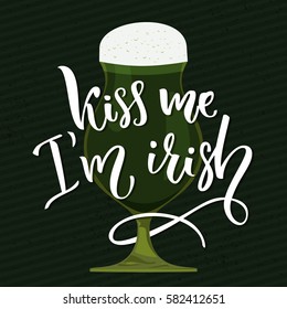Kiss me, I'm irish - handwritten funny st. Patrick's day saying with illustration of green beer glass.