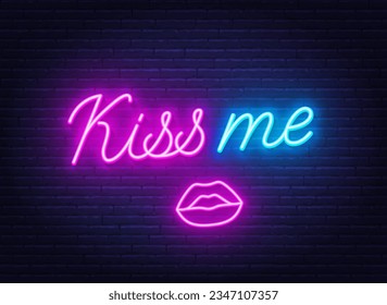 Kiss Me neon sign on brick wall background.