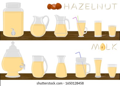 Kit different types pitcher, hazelnut milk in jugs various size. Pitcher consisting of organic plastic jugs for fluid hazelnut milk. Jugs of hazelnut milk it pitcher standing on wooden kitchen table.