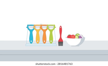 Kitchen counter display featuring four colorful vegetable peelers, a red basting brush, and a salad bowl.