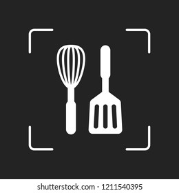 Kitchen tool icon. Whisk and spatula. White object in camera autofocus on dark background