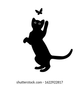 A kitten plays with a flying butterfly. Black silhouette of a cat isolated on white background. The symbol of Halloween. Can be used as a sticker template, logo element, icon for web design.
