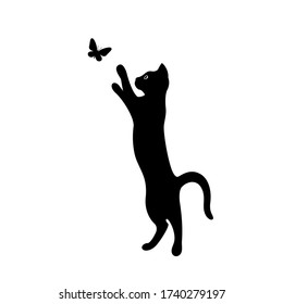 A kitten plays with a flying butterfly. Black silhouette of a cat isolated on white background. The symbol of Halloween. Can be used as a sticker template, logo element, icon for web design.
