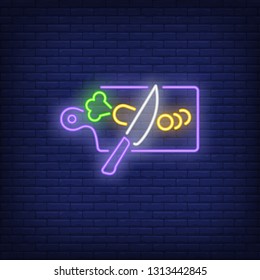Knife cutting carrot on kitchen board neon sign. Cooking and kitchen concept design. Night bright neon sign, colorful billboard, light banner. Vector illustration in neon style.