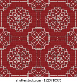 Knitted abstract Christmas pattern, Snowflakes. White on a red background.