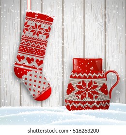 knitted christmas stocking and red tea cup decorated with traditional scandinavian patternin front of white wooden background, vector illustration, eps 10 with transparency and gradient meshes