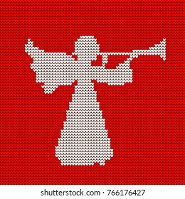 A knitted pattern, a heavenly angel blows a trumpet. Christmas.	