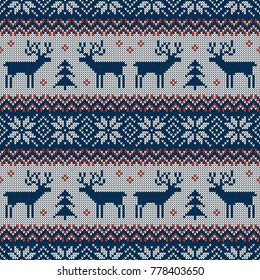 Knitted seamless pattern with deers and traditional scandinavian ornament. Blue, red and white sweater background for Christmas, New Year or winter design. Vector illustration.