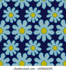Knitted seamless pattern with flowers in blue hues on the dark background, vector as fabric texture